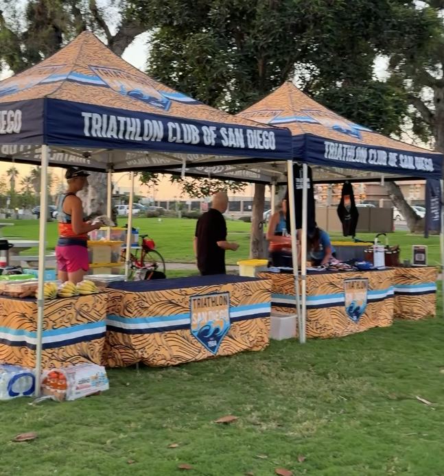 Triathlon Club of San Diego tents and tables set up in a park