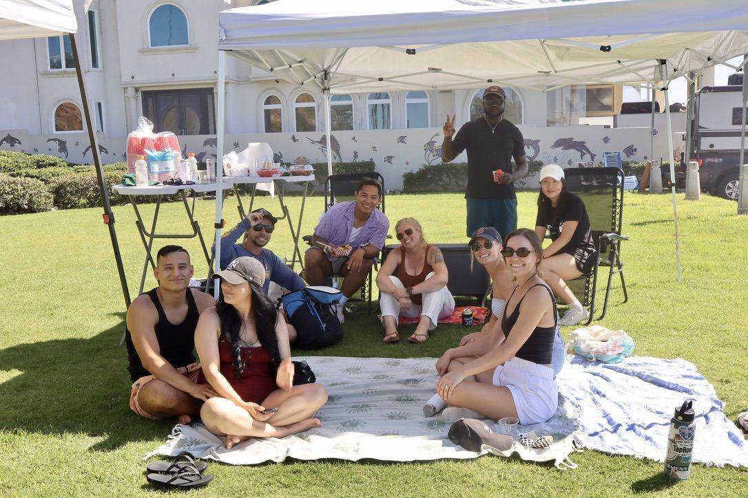 Friends and families relaxing on blankets under the cookout tents