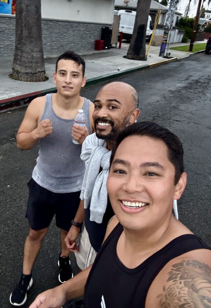 Josh taking a selfie with two run club dads on the street after a run